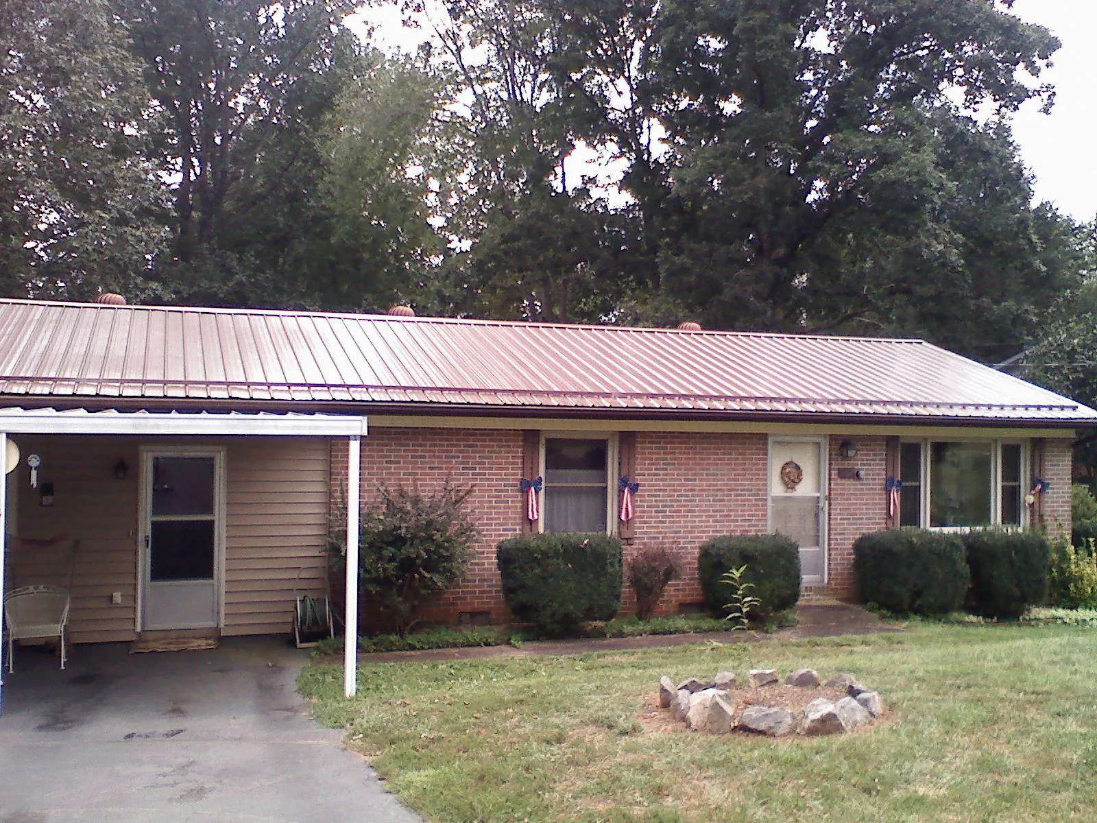 Bronze metal roof and carport on a brick ranch home — Roof Repair work by our crew in Port Costa
